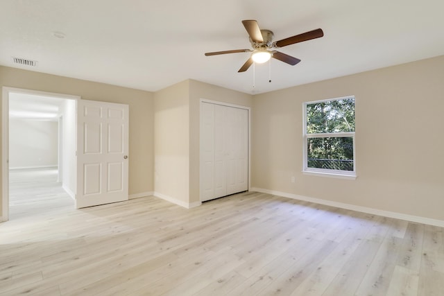 unfurnished bedroom featuring ceiling fan, a closet, and light hardwood / wood-style flooring