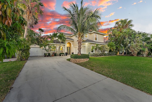 mediterranean / spanish-style house featuring a lawn and a garage