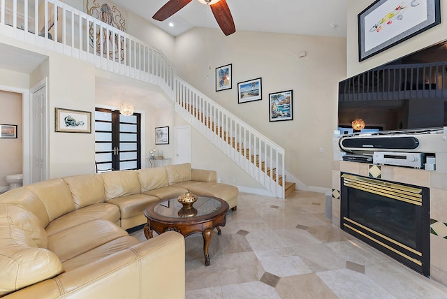 living room with a fireplace, french doors, high vaulted ceiling, and ceiling fan