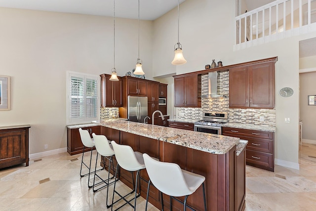 kitchen featuring wall chimney exhaust hood, hanging light fixtures, tasteful backsplash, high vaulted ceiling, and appliances with stainless steel finishes