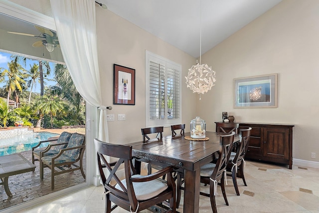 tiled dining space featuring ceiling fan with notable chandelier and vaulted ceiling