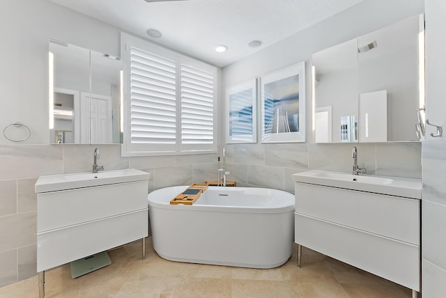 bathroom with tile patterned flooring, a bath, vanity, and tile walls