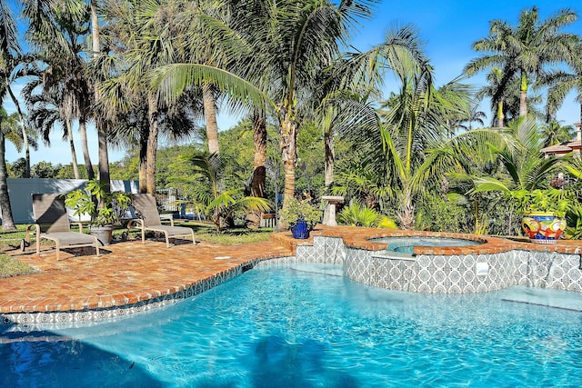 view of swimming pool featuring an in ground hot tub and a patio area