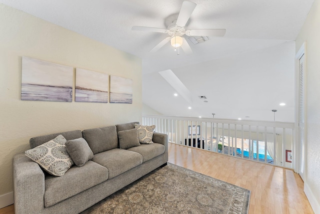 living room featuring ceiling fan, lofted ceiling, and hardwood / wood-style flooring