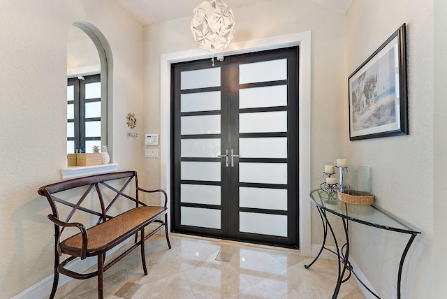 entryway featuring a notable chandelier and french doors