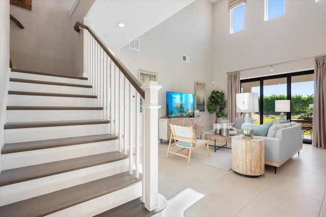 tiled living room with a towering ceiling