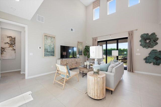 living room featuring light tile patterned flooring, a towering ceiling, and a wealth of natural light