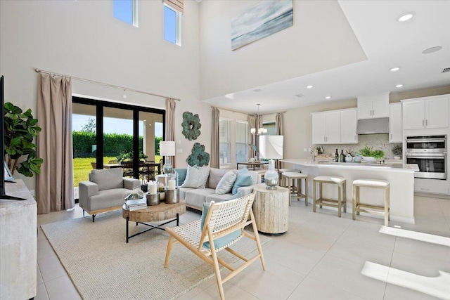 living room featuring light tile patterned floors, a notable chandelier, and sink