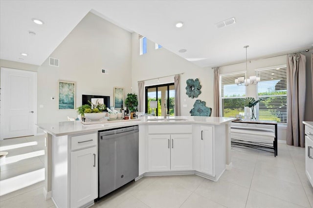 kitchen featuring hanging light fixtures, stainless steel dishwasher, an island with sink, a chandelier, and white cabinets