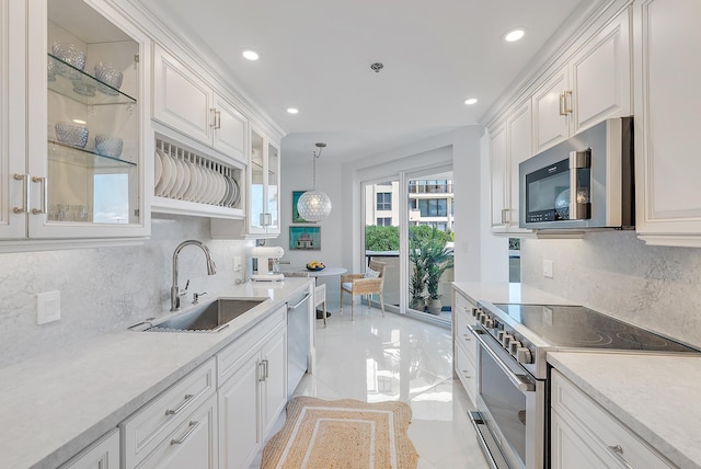 kitchen with sink, stainless steel appliances, tasteful backsplash, pendant lighting, and white cabinets