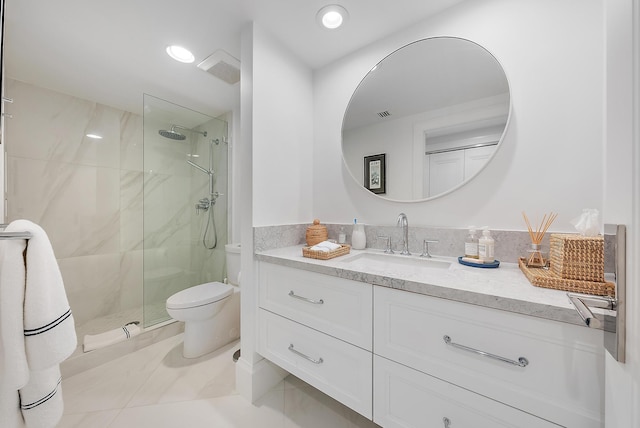 bathroom with tiled shower, tile patterned flooring, vanity, and toilet