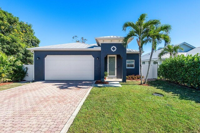 view of front of home featuring a garage and a front lawn