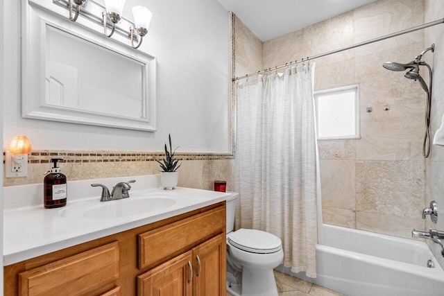 full bath featuring tile patterned flooring, vanity, tile walls, wainscoting, and shower / bath combo