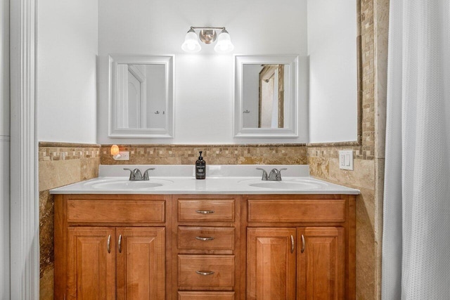 full bathroom with double vanity, tile walls, and a sink