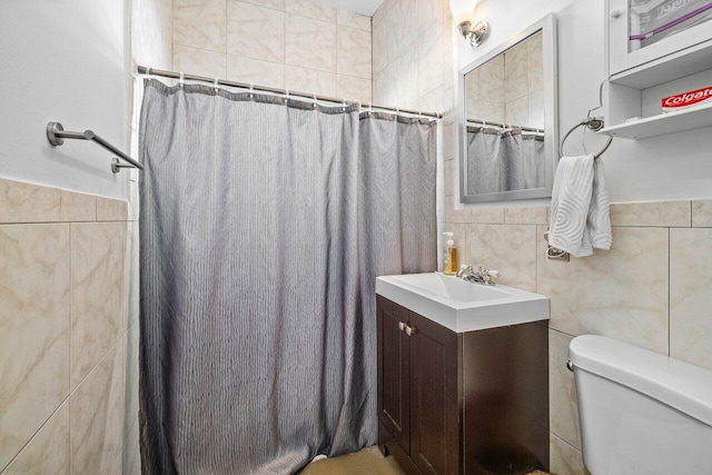 bathroom featuring vanity, toilet, tile walls, and curtained shower