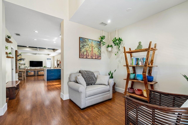 sitting room with ceiling fan and dark wood-type flooring