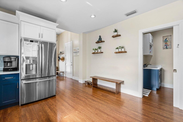 kitchen with blue cabinetry, white cabinetry, dark hardwood / wood-style floors, and stainless steel refrigerator with ice dispenser