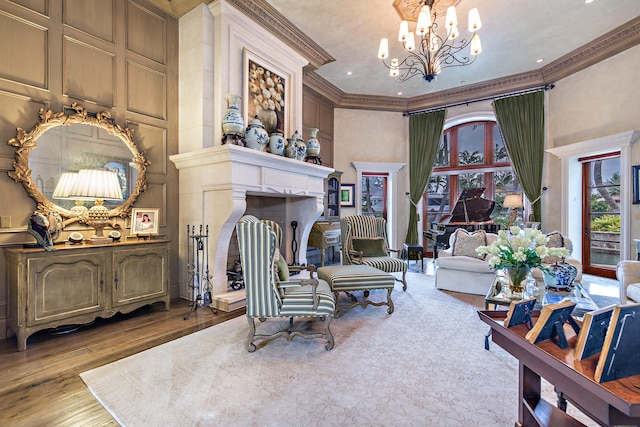 living area with light wood-type flooring, ornamental molding, and a notable chandelier