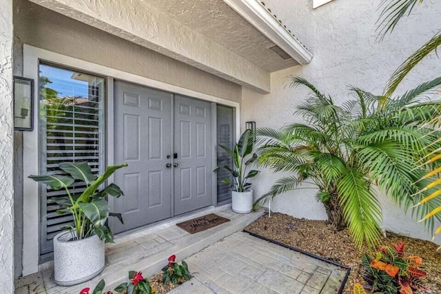 view of exterior entry with stucco siding