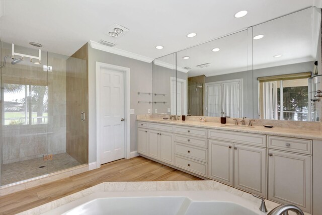 bathroom with crown molding, plenty of natural light, vanity, and hardwood / wood-style flooring