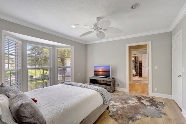 bedroom featuring a textured ceiling, ceiling fan, light hardwood / wood-style floors, and crown molding