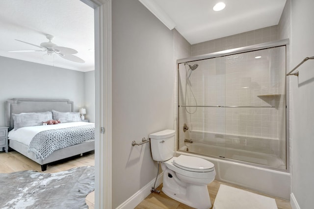 bathroom with ceiling fan, crown molding, enclosed tub / shower combo, hardwood / wood-style floors, and toilet