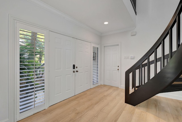 entrance foyer featuring ornamental molding and light wood-type flooring