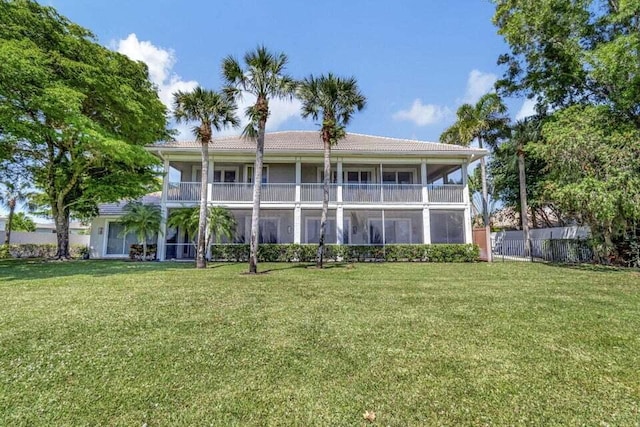 rear view of property featuring a balcony and a lawn