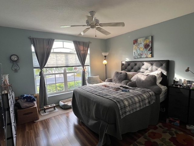 bedroom featuring ceiling fan, wood-type flooring, and a textured ceiling