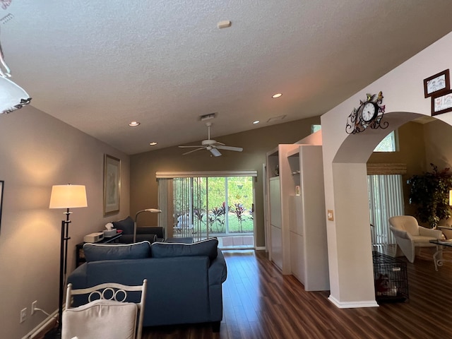 living room with a textured ceiling, dark wood-type flooring, ceiling fan, and lofted ceiling