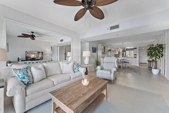 tiled living room with a textured ceiling and ceiling fan