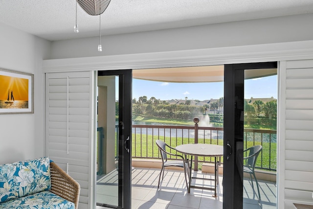 doorway to outside with light tile patterned floors and a textured ceiling