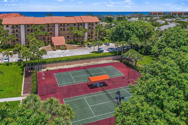 view of tennis court featuring a water view