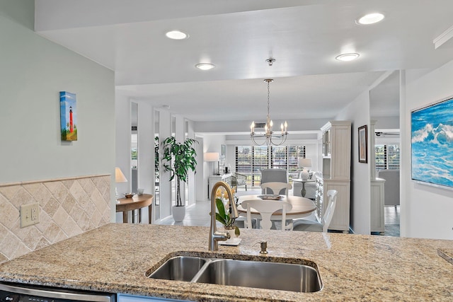 kitchen featuring backsplash, stainless steel dishwasher, plenty of natural light, and sink