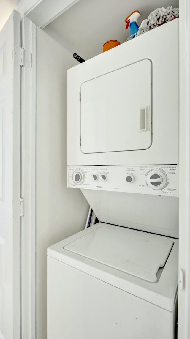 washroom with stacked washing maching and dryer