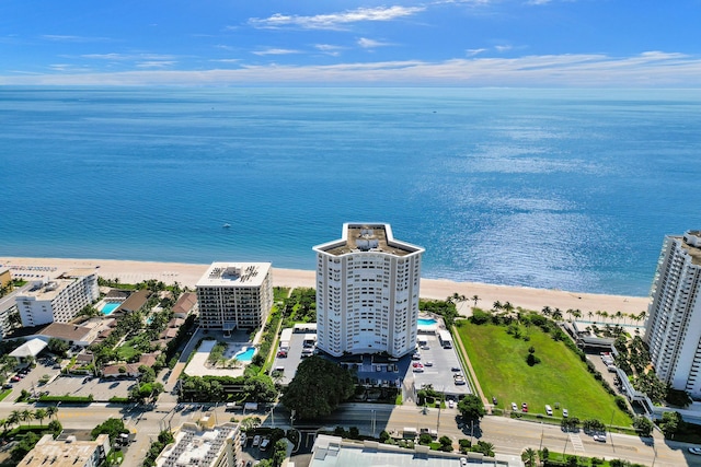 birds eye view of property with a water view and a beach view