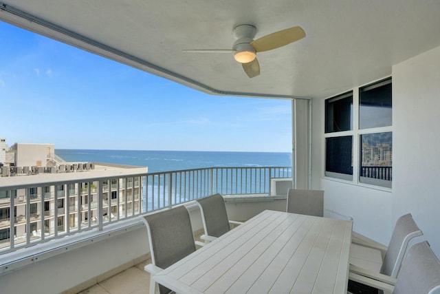 balcony with ceiling fan and a water view