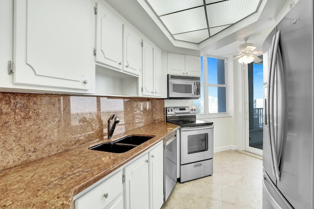 kitchen featuring ceiling fan, sink, tasteful backsplash, white cabinets, and appliances with stainless steel finishes