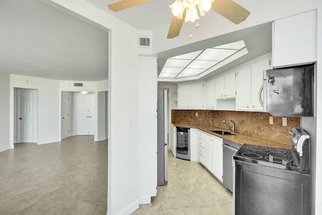 kitchen featuring white cabinets, sink, decorative backsplash, stainless steel appliances, and beverage cooler