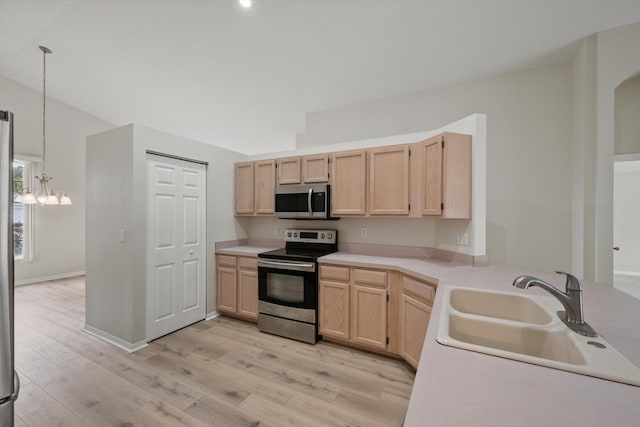 kitchen featuring light brown cabinetry, sink, hanging light fixtures, and appliances with stainless steel finishes