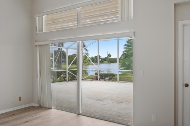 doorway to outside featuring a water view and light hardwood / wood-style floors