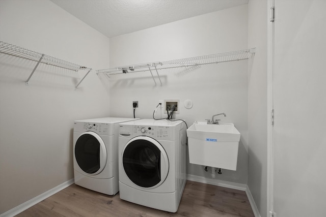 laundry room with separate washer and dryer, sink, hardwood / wood-style flooring, and a textured ceiling