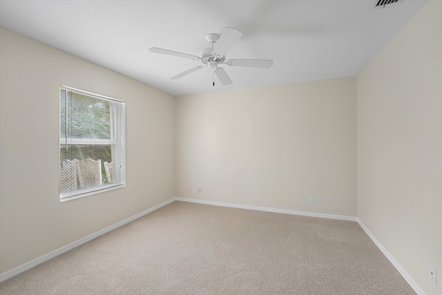 spare room featuring ceiling fan and carpet floors