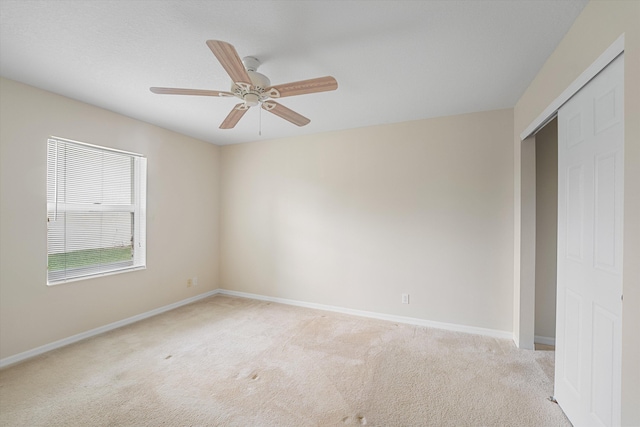 unfurnished room featuring ceiling fan and light colored carpet