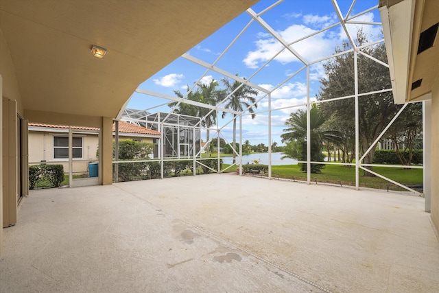 view of patio featuring a water view and glass enclosure