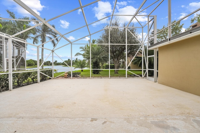 view of patio featuring a lanai and a water view