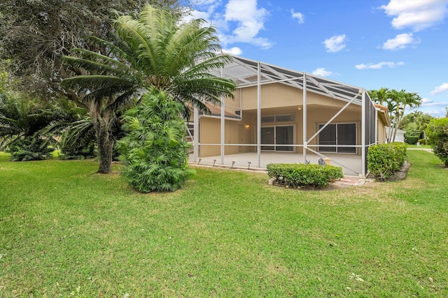 back of house featuring a lanai and a lawn