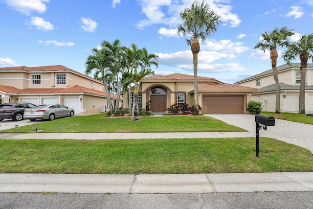 mediterranean / spanish home with a garage and a front lawn