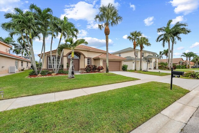 mediterranean / spanish house with a garage, a front yard, and central air condition unit