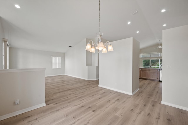 spare room with lofted ceiling, a notable chandelier, and light hardwood / wood-style flooring